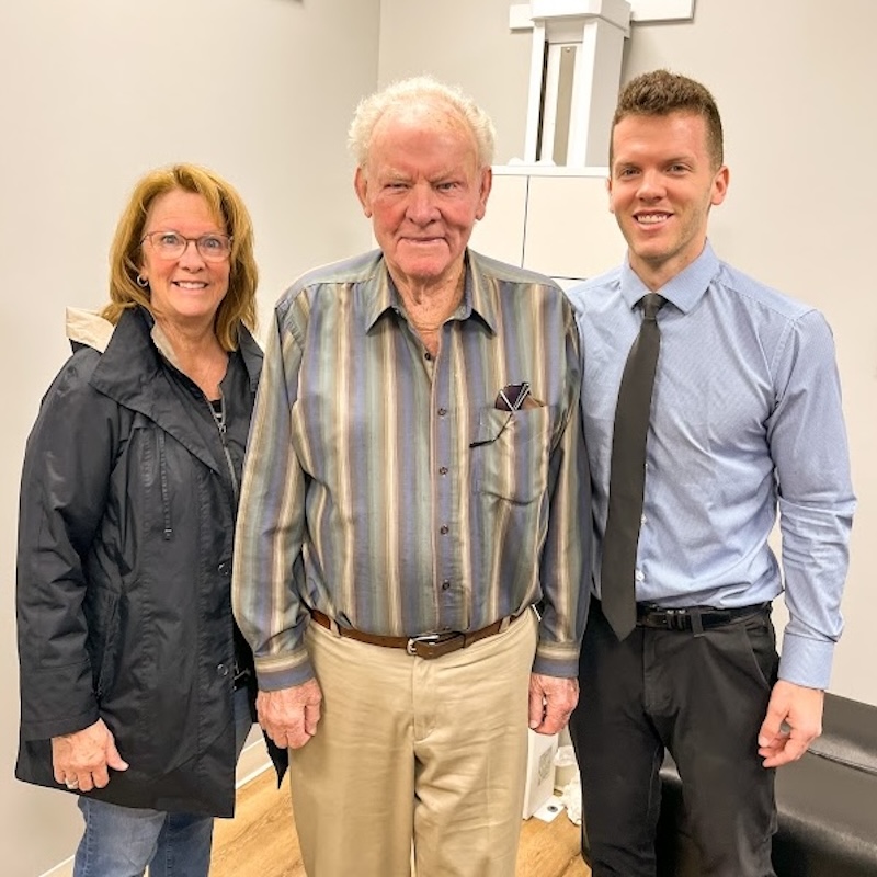 Dr. Nicholas Esser wirh Older couple with a chiropractic professional in a clinic setting